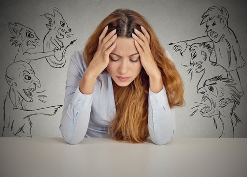 Evil Men pointing at stressed woman. Desperate young businesswoman sitting at desk in her office isolated on grey wall background. Negative human emotions face expression feelings life perception Evil Men pointing at stressed woman. Desperate young businesswoman sitting at desk in her office isolated on grey wall background. Negative human emotions face expression feelings life perception